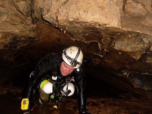 Angy Higgins entering a sump dive in Elk River Cave. Note the side mounted tanks which are easier for underwater squeezing. Photo by Doug Henry